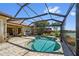 Backyard pool with screened enclosure, patio, and picturesque landscaping at 13136 N Marsh Dr, Port Charlotte, FL 33953