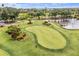 Aerial view of the community putting green with manicured green and beautiful landscaping at 13136 N Marsh Dr, Port Charlotte, FL 33953