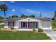 Charming single story home with purple shutters, an attached garage, and a well-maintained front lawn at 1389 Hinton St, Port Charlotte, FL 33952