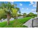 Lush backyard with manicured lawn, mature palms, and serene waterfront views from the paver patio at 14166 Fort Worth Cir, Port Charlotte, FL 33981