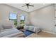 Bright bedroom with two twin beds, neutral walls, hardwood floors, and large windows at 14166 Fort Worth Cir, Port Charlotte, FL 33981