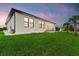 Exterior side view of the house showcasing the modern design, large windows, and green lawn at 14166 Fort Worth Cir, Port Charlotte, FL 33981