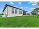 Exterior side view of the house showcasing the modern design, large windows, and green lawn at 14166 Fort Worth Cir, Port Charlotte, FL 33981