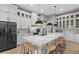 Modern kitchen features a large island with counter seating and black pendant lighting over marble countertops at 14166 Fort Worth Cir, Port Charlotte, FL 33981