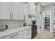 Kitchen featuring white cabinets, quartz countertops, stainless steel appliances, and hardwood floors at 14166 Fort Worth Cir, Port Charlotte, FL 33981
