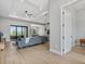 Bright, open-concept living room with wood tile floors, ceiling fan, and large sliding glass doors to the outside patio at 14166 Fort Worth Cir, Port Charlotte, FL 33981