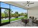 Relax in this screened-in patio with comfortable seating and an outdoor ceiling fan, overlooking a waterfront view at 14166 Fort Worth Cir, Port Charlotte, FL 33981