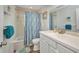 Clean bathroom featuring a shower with curtain, white sink, and soft turquoise accents at 1478 Harmony Dr, Port Charlotte, FL 33952