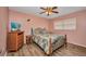 Cozy bedroom with a floral bedspread, wooden furniture, and a ceiling fan at 1478 Harmony Dr, Port Charlotte, FL 33952