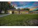 Inviting single-story home with a green lawn and shuttered windows at twilight at 1478 Harmony Dr, Port Charlotte, FL 33952
