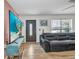 Comfortable living room featuring a plush leather sofa, a modern ceiling fan and a large window at 1478 Harmony Dr, Port Charlotte, FL 33952