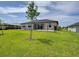 Large backyard with a green lawn, partially enclosed by a black metal fence and trees at 15741 Autry Cir, Port Charlotte, FL 33981