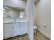 Bathroom features a white vanity, quartz countertop, LED mirror and a view to an adjacent water closet at 15741 Autry Cir, Port Charlotte, FL 33981