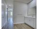 Hallway view to the bathroom with bright vanity and quartz countertop at 15741 Autry Cir, Port Charlotte, FL 33981