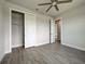 Bright bedroom with wood-look flooring, closet, and doorway showcasing the home's layout at 15741 Autry Cir, Port Charlotte, FL 33981