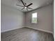 Bedroom showcasing wood-look floors, a ceiling fan, and a bright window with a pleasant view at 15741 Autry Cir, Port Charlotte, FL 33981