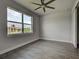 Bedroom featuring a large window, ceiling fan, wood-look tile flooring and baseboard at 15741 Autry Cir, Port Charlotte, FL 33981
