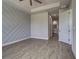 Bright bedroom features wood-look tile flooring and a decorative accent wall, creating a modern and inviting space at 15741 Autry Cir, Port Charlotte, FL 33981