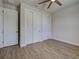 A simple bedroom with a ceiling fan and wood look floors has double-door closets for plenty of storage at 15741 Autry Cir, Port Charlotte, FL 33981