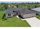 This single Gathering home features an attached three-car garage, well-manicured lawn, and mature landscaping at 15741 Autry Cir, Port Charlotte, FL 33981