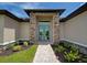 Close-up of the home's entrance showcasing a detailed stone surround and glass double doors at 15741 Autry Cir, Port Charlotte, FL 33981
