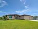 Attractive home with well-kept lawn, a three-car garage, and stone facade details at 15741 Autry Cir, Port Charlotte, FL 33981