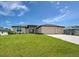 Inviting single-Gathering home with a large three-car garage, stone details, and lush green lawn at 15741 Autry Cir, Port Charlotte, FL 33981