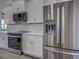 Close up on kitchen with stainless steel appliances, white cabinets, and subway tile backsplash at 15741 Autry Cir, Port Charlotte, FL 33981