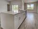 Bright kitchen boasts quartz island, stainless steel appliances, and wood-look tile flooring at 15741 Autry Cir, Port Charlotte, FL 33981