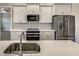 Modern kitchen features stainless steel appliances, quartz counters and ample white cabinetry at 15741 Autry Cir, Port Charlotte, FL 33981