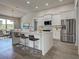 Modern kitchen features a center island with bar seating, stainless appliances, and bright countertops at 15741 Autry Cir, Port Charlotte, FL 33981