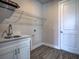 Convenient laundry room with sink, white cabinets, quartz counters, and plenty of storage at 15741 Autry Cir, Port Charlotte, FL 33981