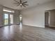Spacious living room boasts wood-look tile floors and access to a patio through glass doors at 15741 Autry Cir, Port Charlotte, FL 33981