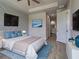 Stylishly furnished main bedroom featuring accent wall, en-suite bathroom and light filled space at 15741 Autry Cir, Port Charlotte, FL 33981