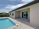 Backyard pool with brick patio and sliding glass doors at 15741 Autry Cir, Port Charlotte, FL 33981