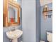 Charming powder room featuring blue walls, a rustic mirror, and coastal-themed decor at 16833 Terrapin Key Dr, Port Charlotte, FL 33953
