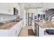 Well-lit kitchen with stainless appliances, granite counters, white cabinetry, and pantry at 16833 Terrapin Key Dr, Port Charlotte, FL 33953