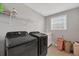 Laundry room featuring modern washer and dryer, storage shelves, and window at 16833 Terrapin Key Dr, Port Charlotte, FL 33953