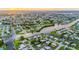 Areal view showcases a community with canals and waterfront properties, surrounded by lush greenery at 180 Palmetto Ne Cir, Port Charlotte, FL 33952