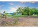 A single-story home boasting mature landscaping with trees and a spacious backyard, perfect for outdoor living at 180 Palmetto Ne Cir, Port Charlotte, FL 33952