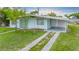 Charming single story home with neutral paint, covered parking and sidewalk to the front door at 180 Palmetto Ne Cir, Port Charlotte, FL 33952