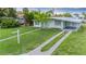 Charming single-Gathering home with a well-manicured lawn, mature trees, and a covered carport at 180 Palmetto Ne Cir, Port Charlotte, FL 33952