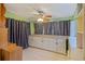 Another view of a room with neutral colored cabinets, window, and star-patterned curtains at 180 Palmetto Ne Cir, Port Charlotte, FL 33952