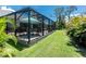 Backyard features a screened-in patio and lush landscaping at 185 Hercules Dr, Rotonda West, FL 33947