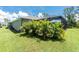 Backyard boasts a spacious lawn with lush tropical trees at 185 Hercules Dr, Rotonda West, FL 33947