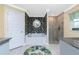 Elegant bathroom featuring a soaking tub, glass-enclosed shower, and stylish tropical-themed wallpaper at 185 Hercules Dr, Rotonda West, FL 33947