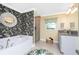 Bright bathroom features a soaking tub, decorative mirror, and tropical floral wallpaper at 185 Hercules Dr, Rotonda West, FL 33947