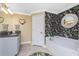 Bathroom featuring a soaking tub, tropical floral wallpaper and granite countertop at 185 Hercules Dr, Rotonda West, FL 33947