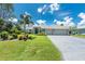 Charming one-story home featuring a well-kept lawn, lush landscaping, and a convenient three-car garage at 185 Hercules Dr, Rotonda West, FL 33947