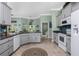 Well-lit kitchen with stainless steel appliances, granite countertops, and tile flooring with gray cabinets at 185 Hercules Dr, Rotonda West, FL 33947
